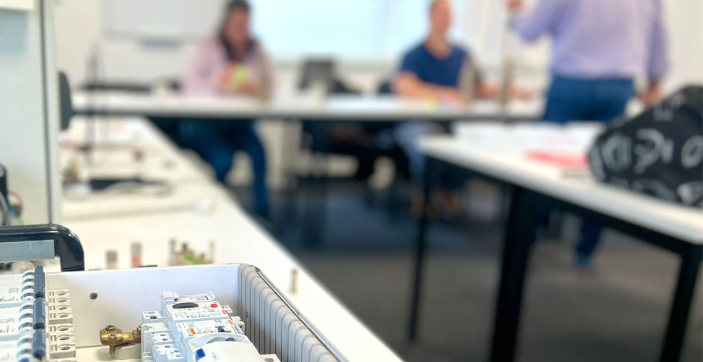 Séance de formation habilitation électrique en salle avec formateur et groupe mixte de stagiaires électriciens et non-électriciens